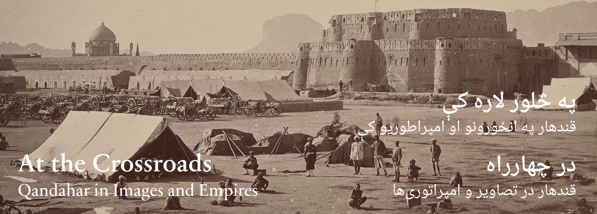 A sepia photograph shows tents and soldiers sitting in a field in the foreground with a stone citadel in the background.