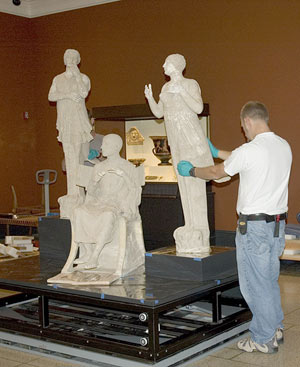 Preparator installing Poet and Sirens sculpture in the Getty Villa