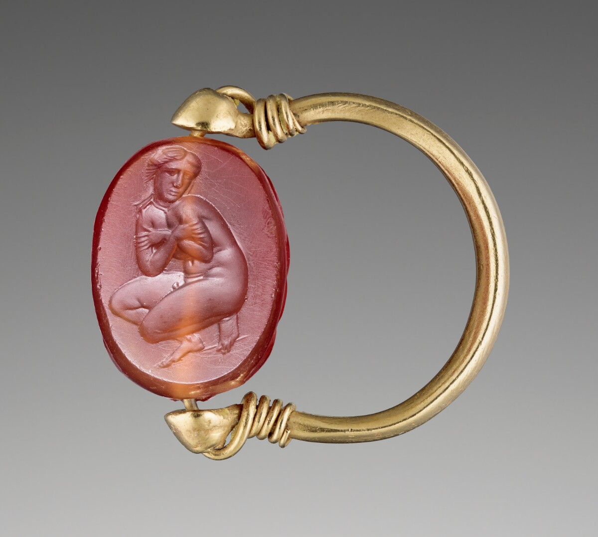 A red gem with a nude woman and gold band