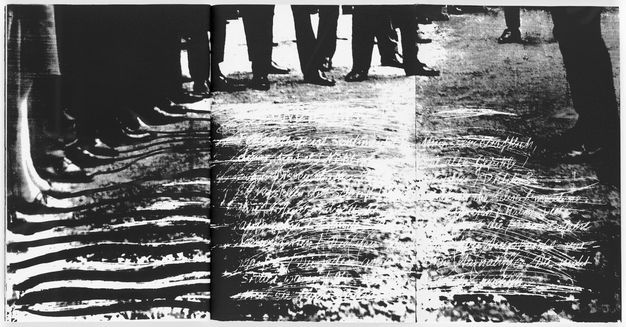 Black and white spread depicting the ground with scratched-out text underneath a semicircle of standing individuals' feet and lower legs.