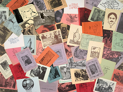 A scattering of postcards from the College of 'Pataphysics in pale blues, greens, oranges, pinks, and yellows, depicting a line drawing of writer Alfred Jarry's face, a whimsical map of the world, and photographs of men, among others. 